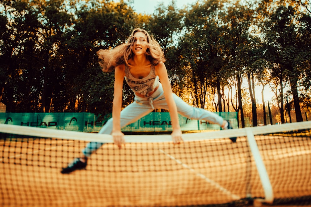 woman jumping over net