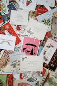 A collection of cute and retro Christmas card designs fanned out on a soft fabric background.