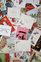 A collection of vintage and colorful Christmas cards, featuring various designs such as Santa Claus, nativity scenes, Christmas trees, and winter landscapes. Some cards have handwritten messages and printed greetings.