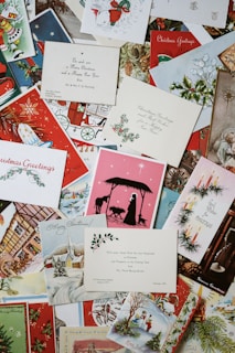 A collection of vintage and colorful Christmas cards, featuring various designs such as Santa Claus, nativity scenes, Christmas trees, and winter landscapes. Some cards have handwritten messages and printed greetings.