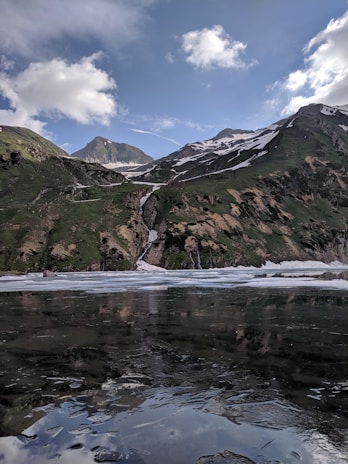 A serene Himalayan landscape with snow-capped peaks and a pristine water source at dawn.
