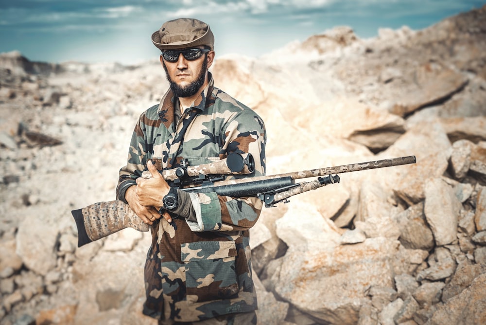 selective focus photography of standing man holding rifle