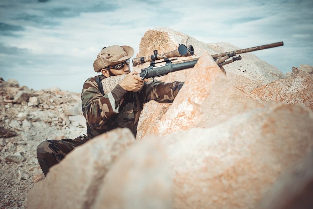 selective focus photography of man using rifle