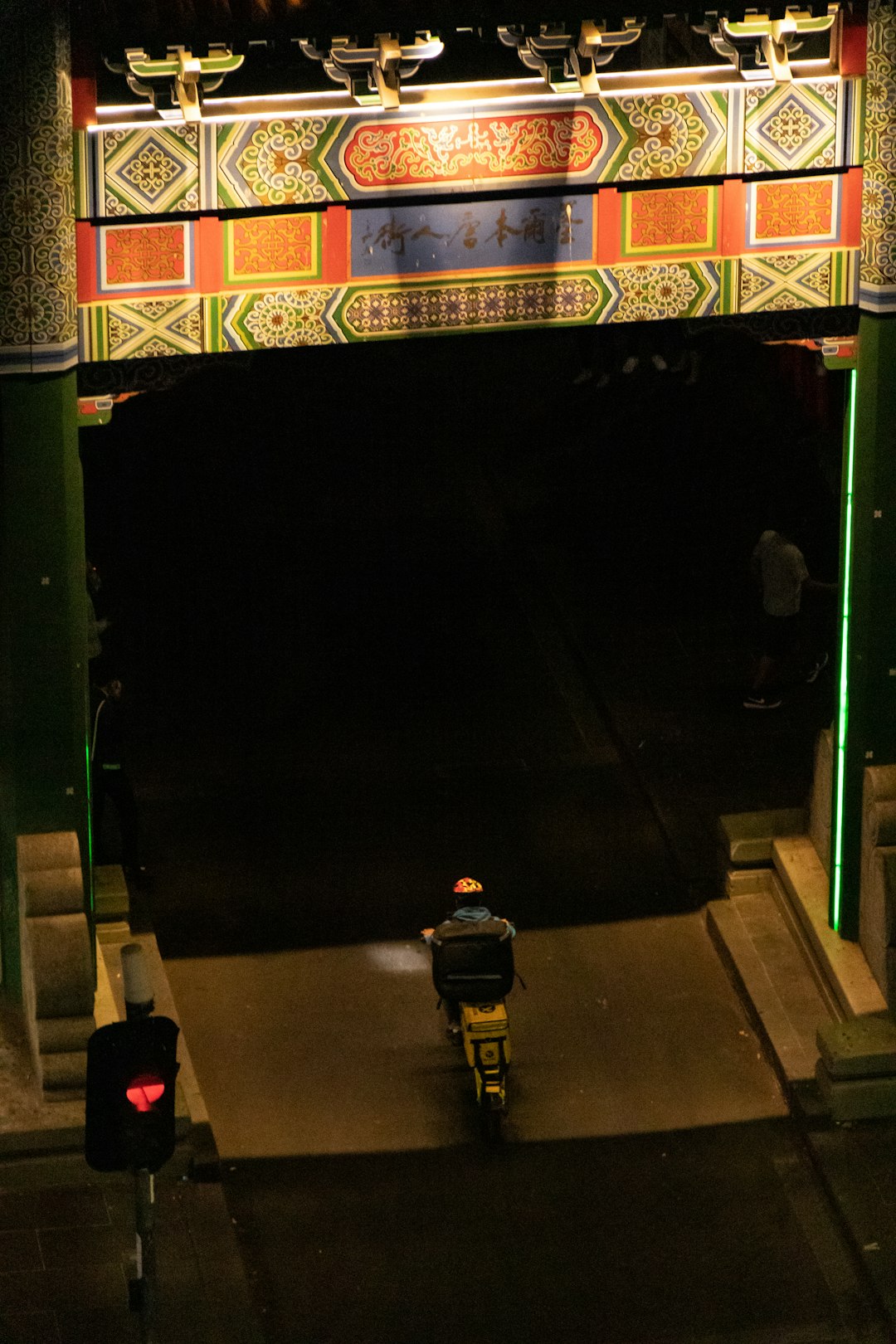 man riding motorcycle passing arch