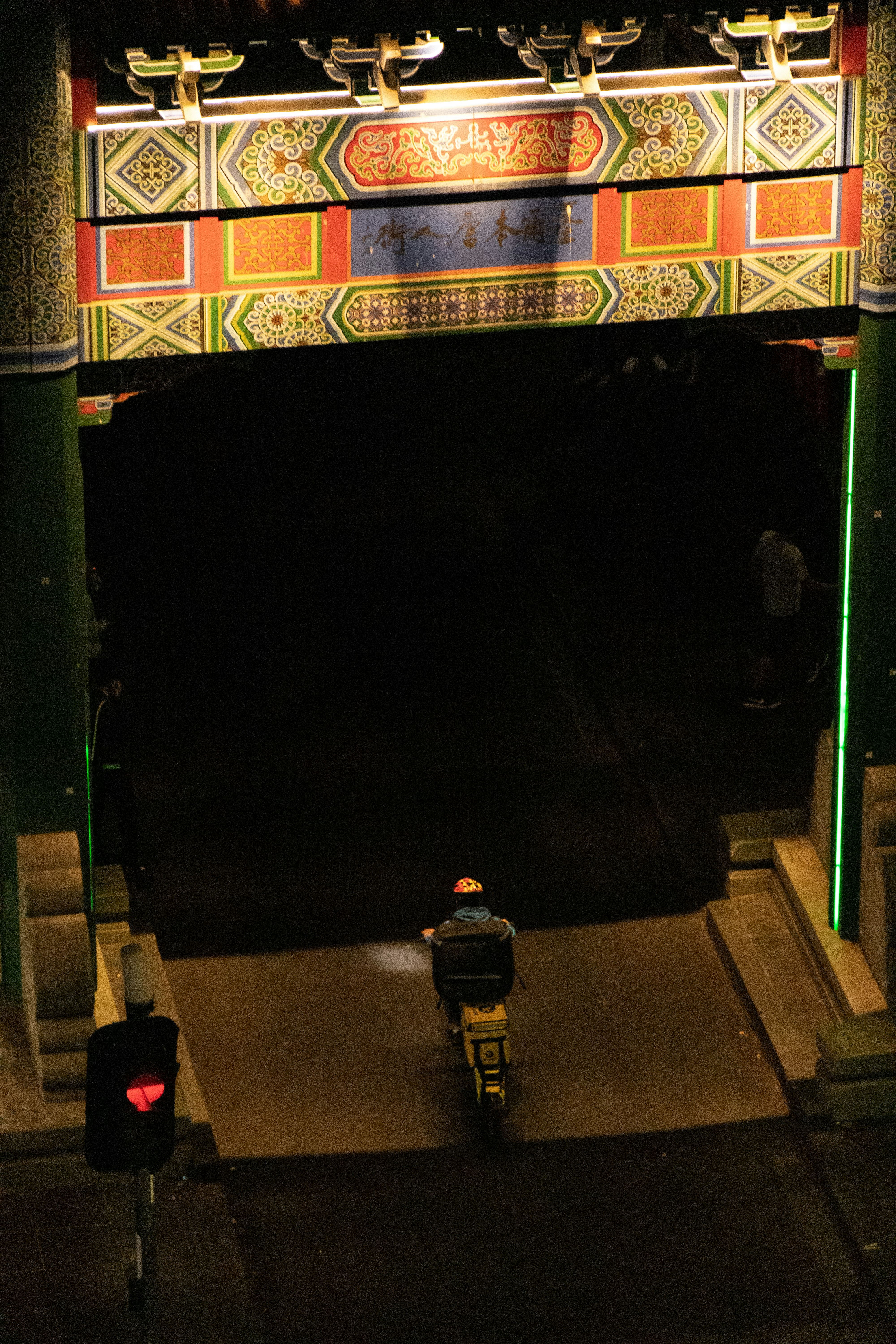 man riding motorcycle passing arch