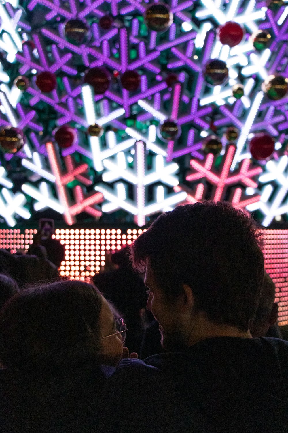 a group of people standing in front of a christmas tree