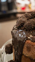 Close-up of a freshly baked chocolate cake with rich frosting and decorative sprinkles.