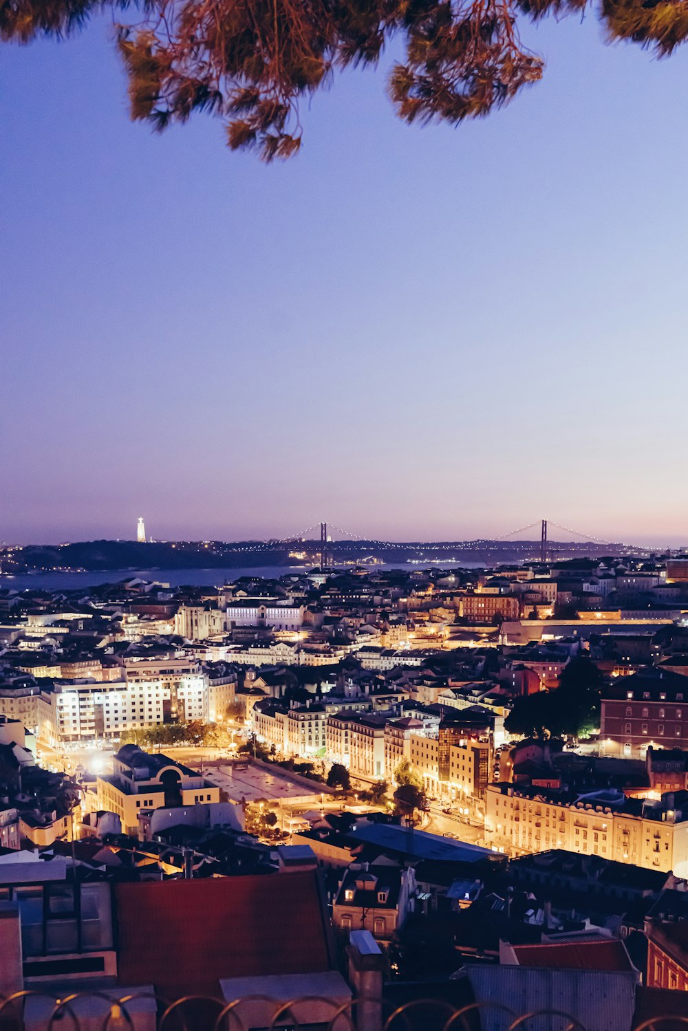 uma vista de uma cidade à noite do topo de uma colina