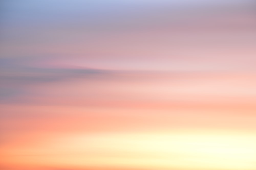 a plane flying in the sky at sunset