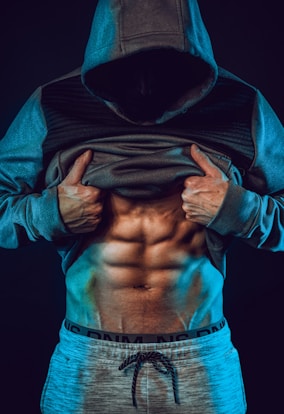 man in gray hoodie showing muscle