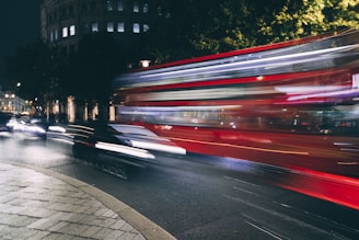 Nighttime cityscape of London with a Surbiton Airport Transport vehicle driving smoothly.