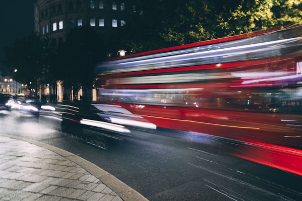 Nighttime cityscape of London with a Surbiton Airport Transport vehicle driving smoothly.