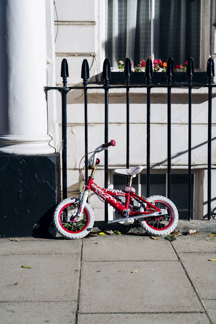 BMX bike parked beside fence and building during day