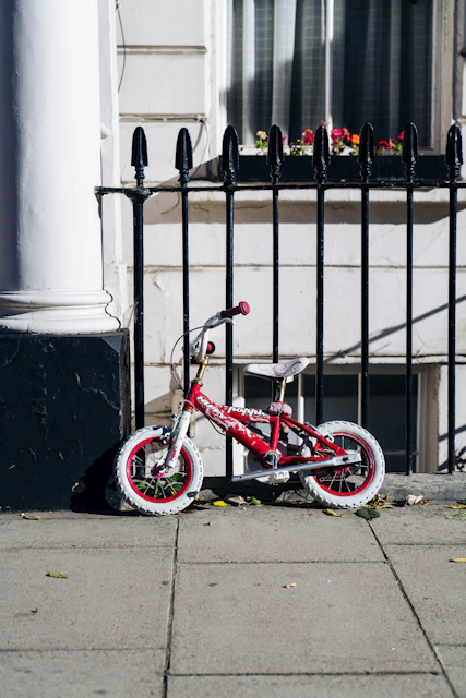 BMX bike parked beside fence and building during day