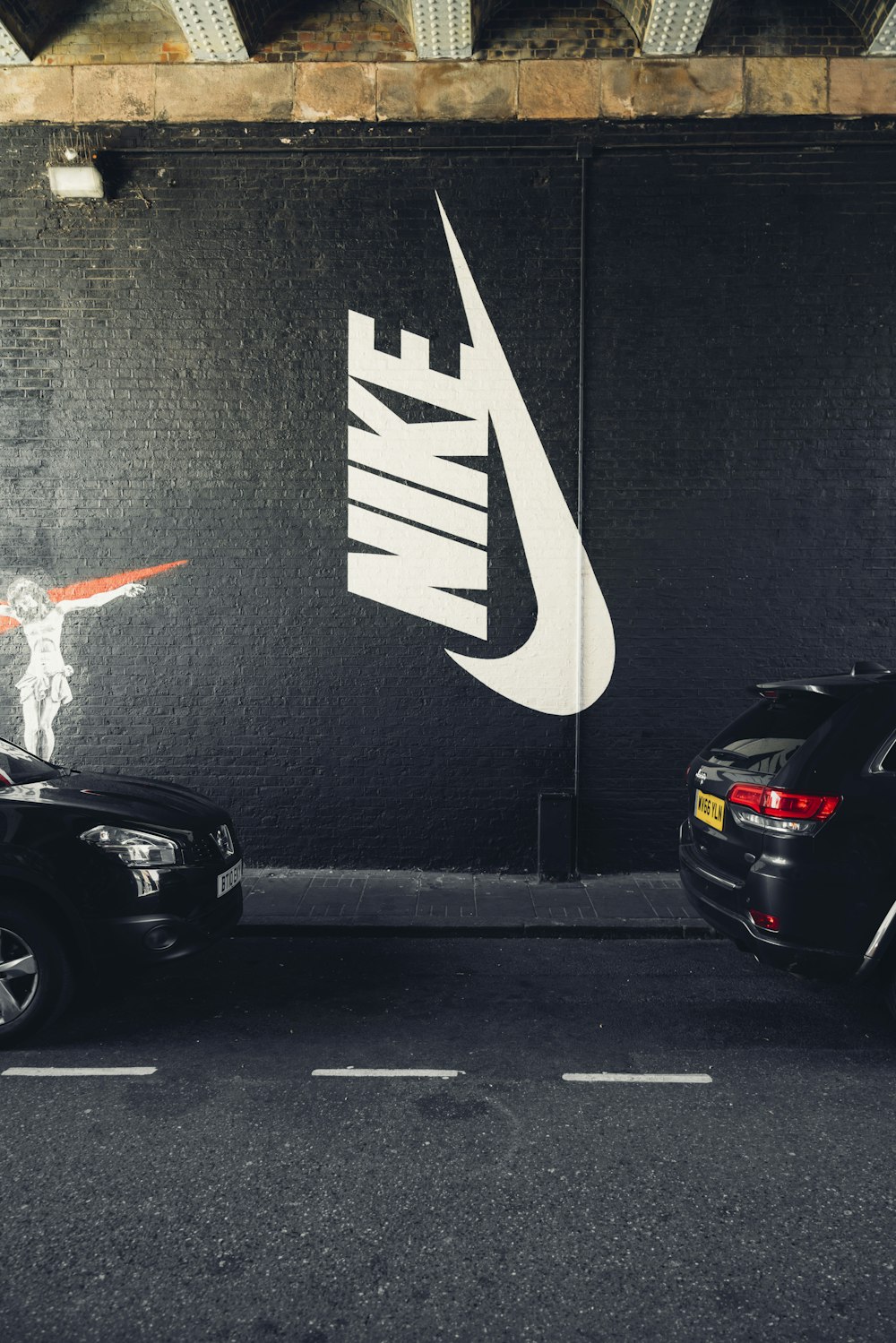 parked vehicles beside Nike wall