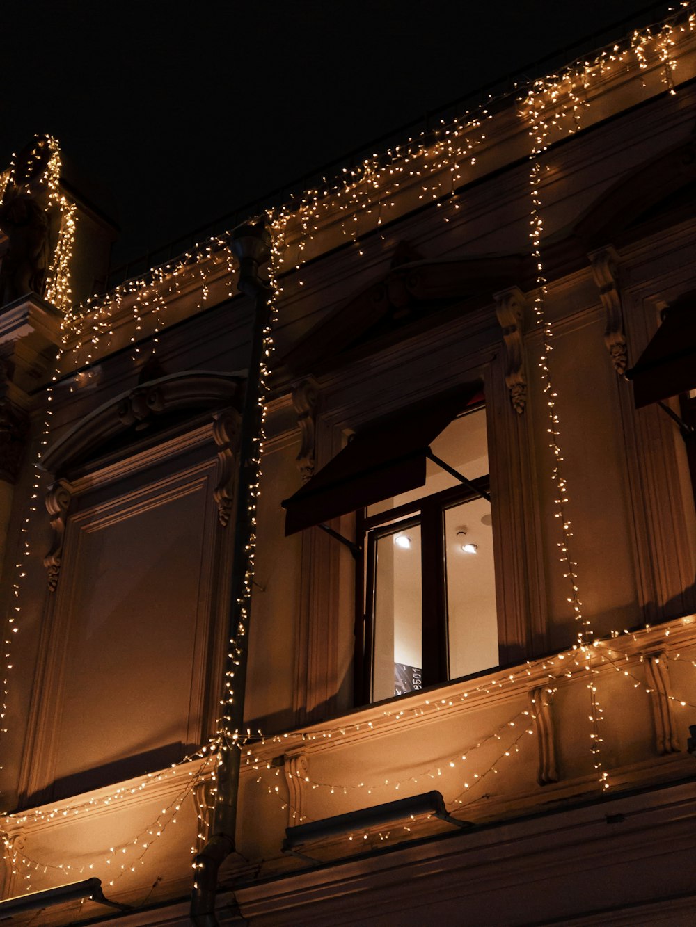 building with turned on string lights during night