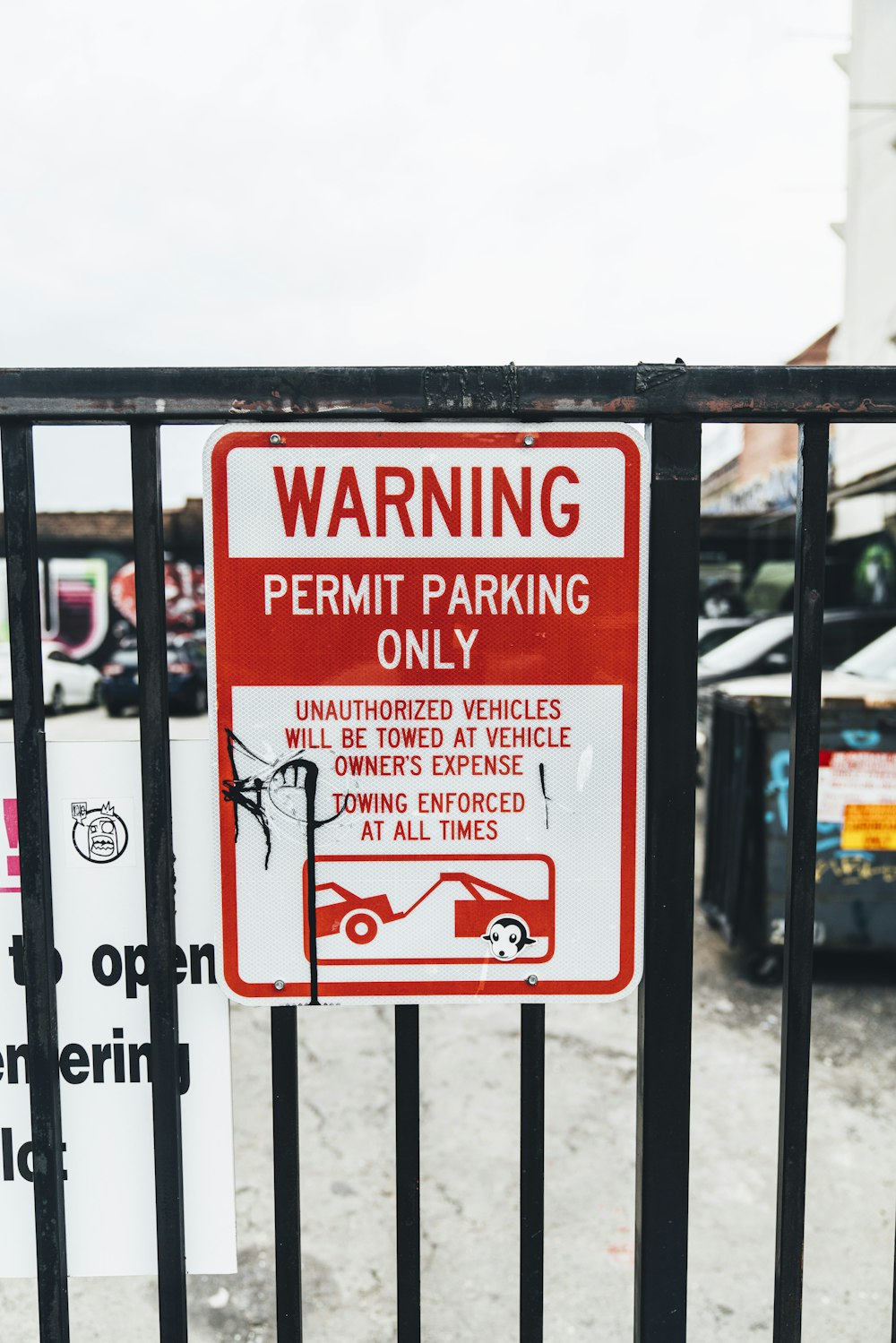 warning permit parking only sign on fence