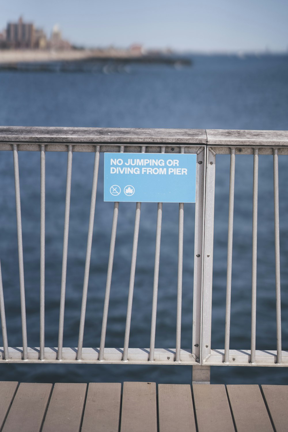 No jumping or diving from pier sign on metal fence
