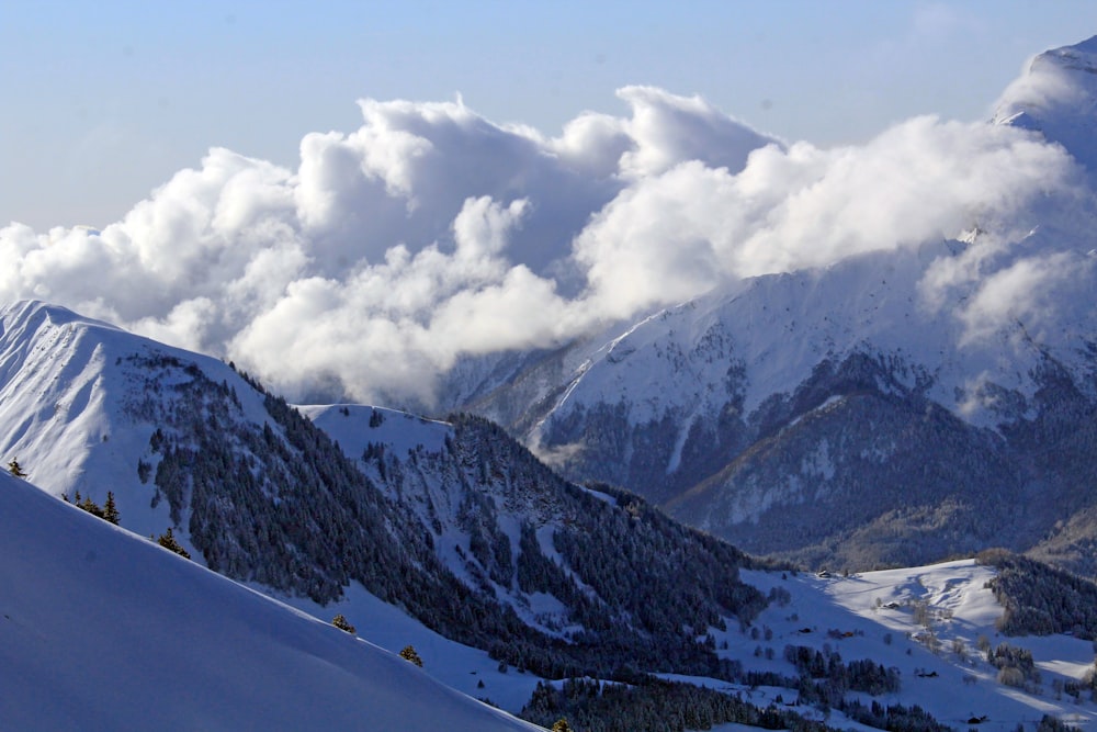 Photographie aérienne de champs et de montagnes couverts de neige sous un ciel blanc et bleu