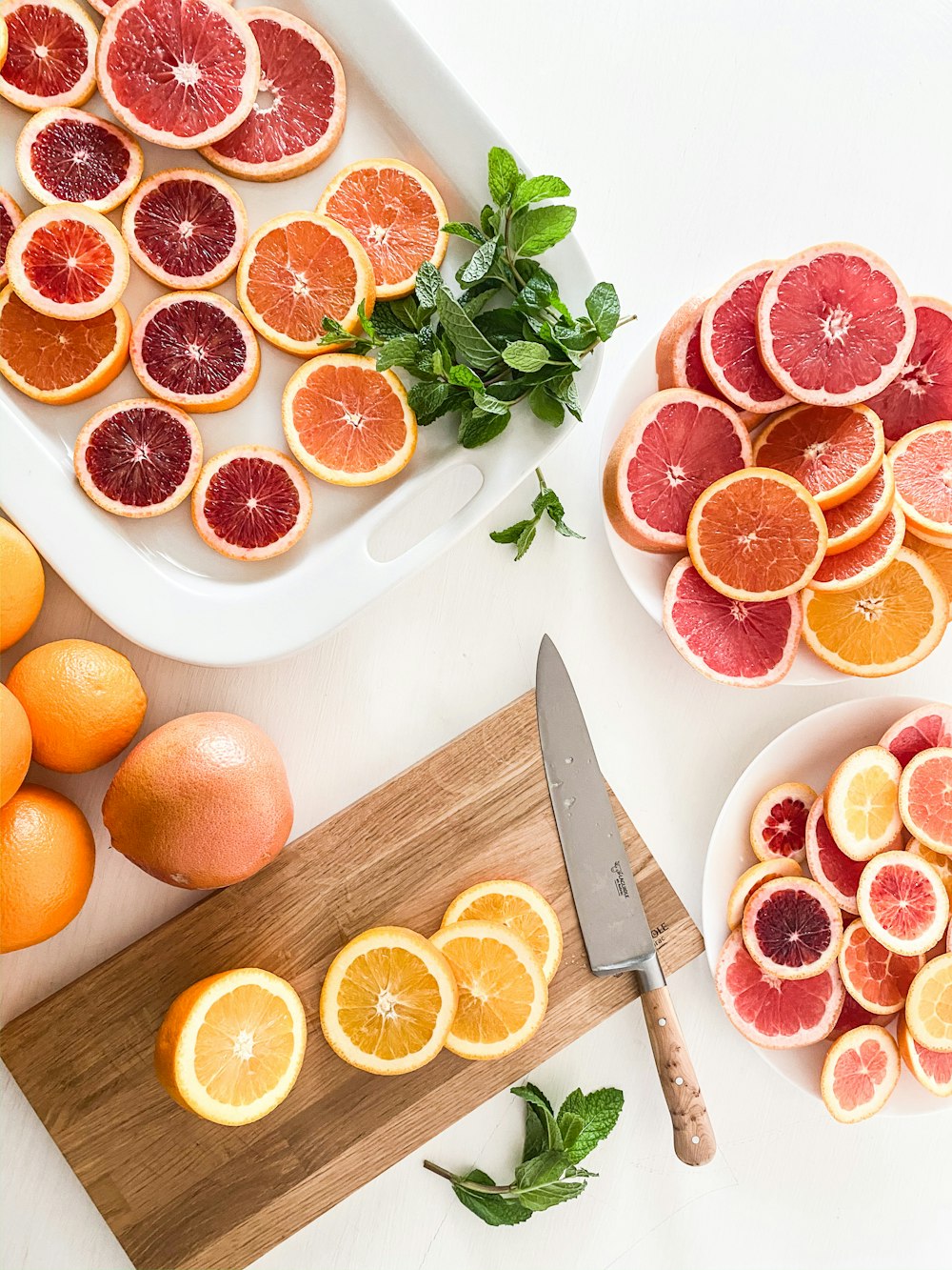 ein Schneidebrett mit in Scheiben geschnittenen Orangen neben einem Messer