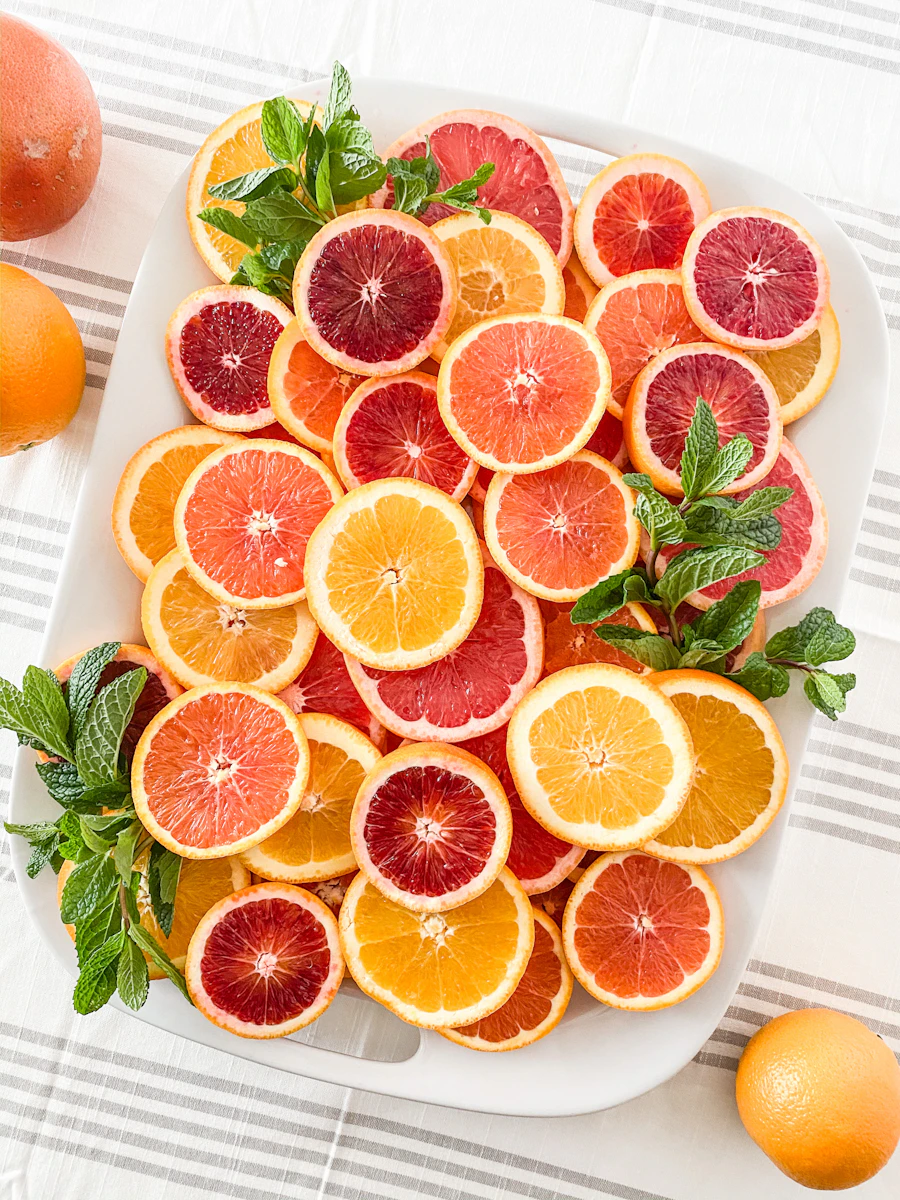 Assiette d'agrumes colorés coupés en tranches : oranges sanguines, pamplemousses et citrons