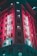 A tall building featuring retro-style neon signage with the word 'Gowings' displayed vertically. The structure is illuminated in vibrant pink and teal lights, creating a striking contrast. The architecture appears to be from the early 20th century, with multiple windows visible across its facade.