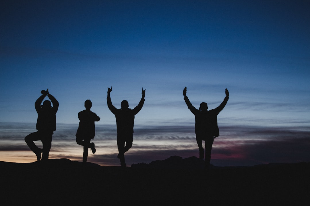 silhouette of men under blue sky