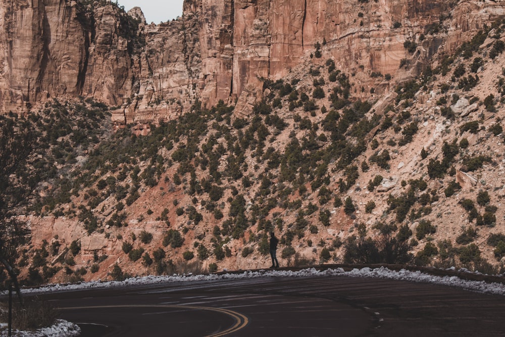 woman standing beside empty road