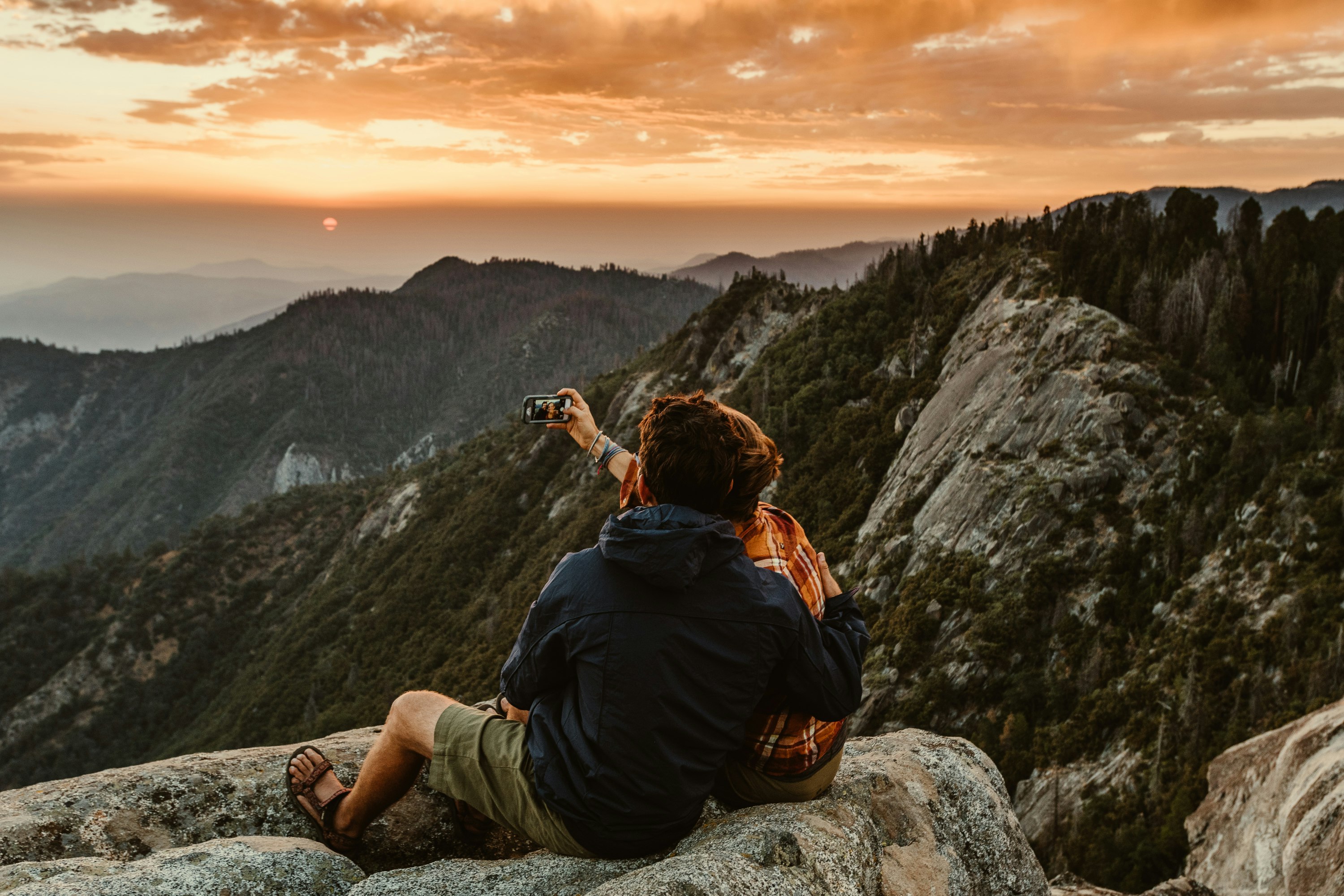 couple sitting on rock during daytime