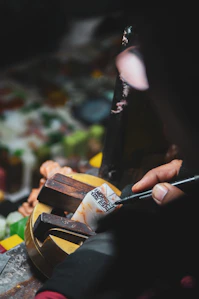 A close-up of a craftsman carefully engraving a custom acrylic keychain in a cozy workshop.