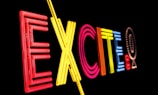 Bright neon letters spell out the word 'EXCITE' against a black background, using a variety of colors including red, yellow, pink, and blue.