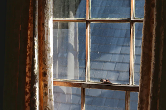 A cozy nook bathed in sunlight through a wide sliding window with wooden trim.