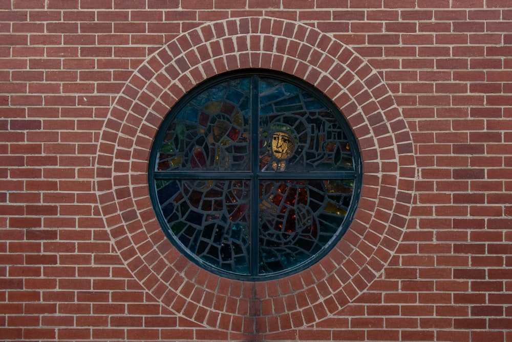 a round window in a brick wall with stained glass
