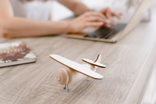 A focused student pilot studying FAA private pilot materials with a model airplane on the desk.