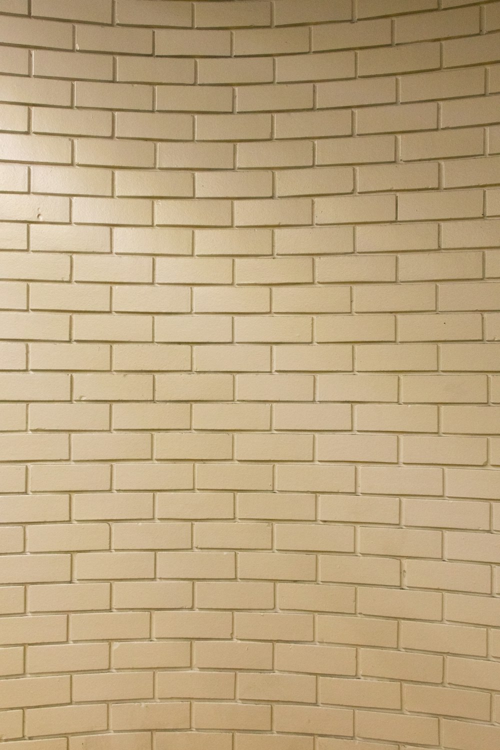 a bathroom with a toilet and a tiled wall