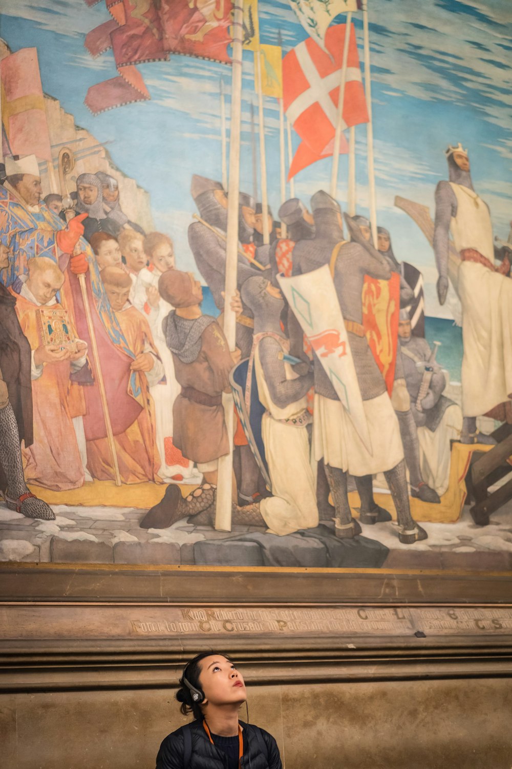 a woman sitting on a bench in front of a painting