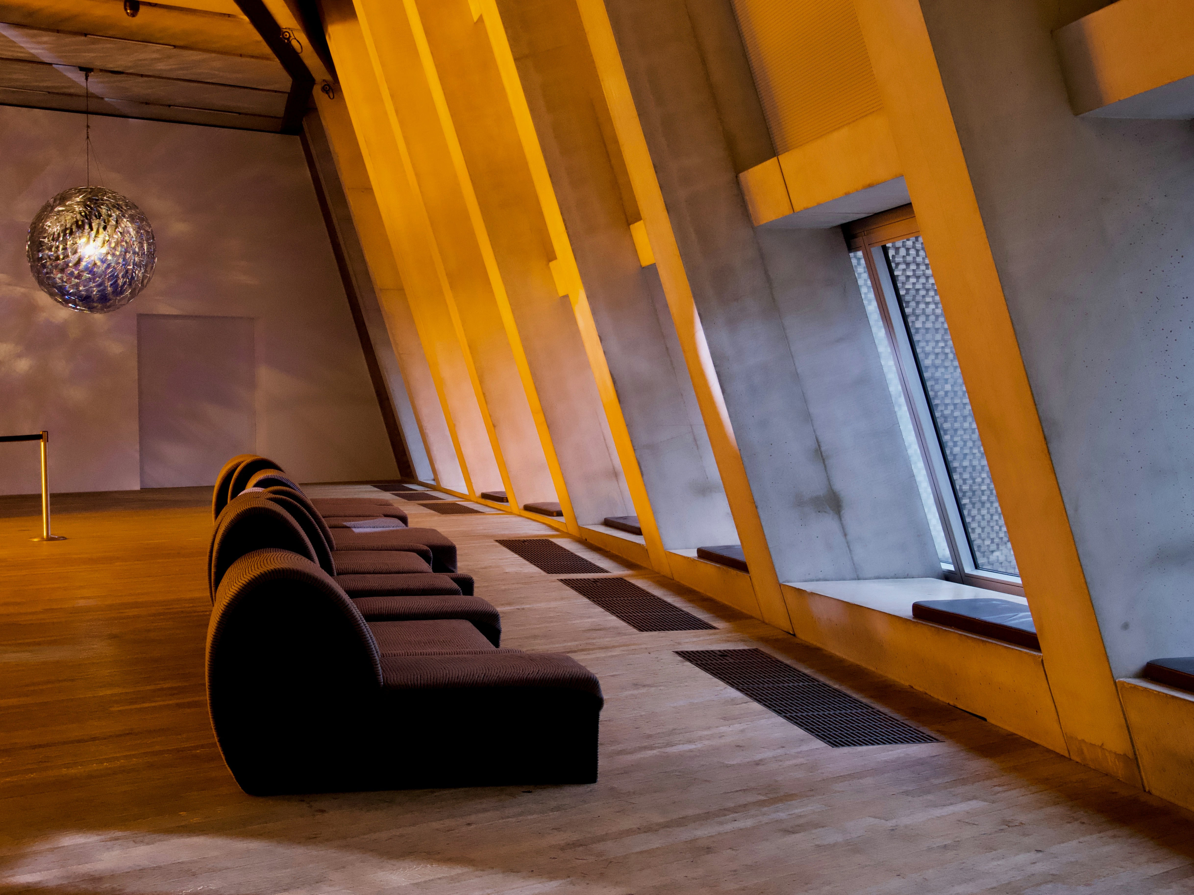 A lounge area illuminated with yellow orange light from a chic disco ball at the Tate Modern, one of the infamous British museums
