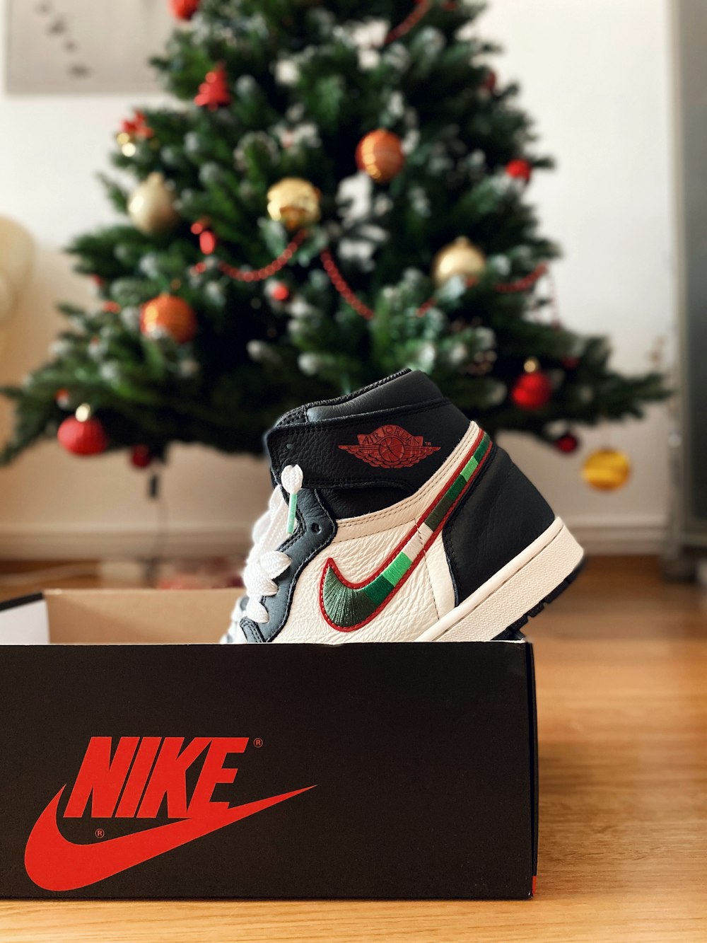 Zapatilla Nike de caña alta en caja cerca del árbol de Navidad
