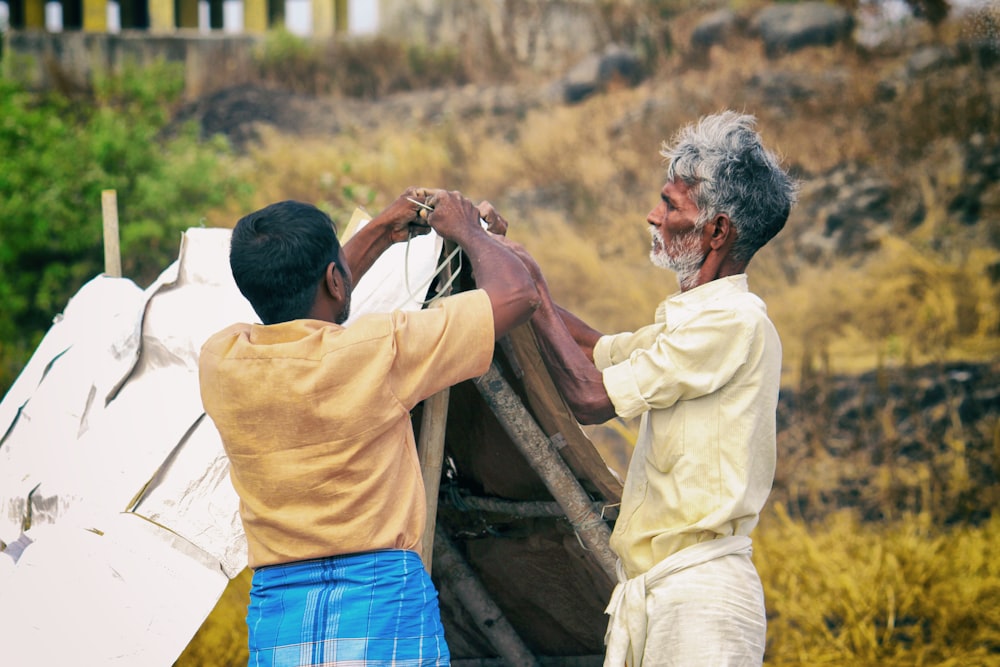 two men fixing a tent