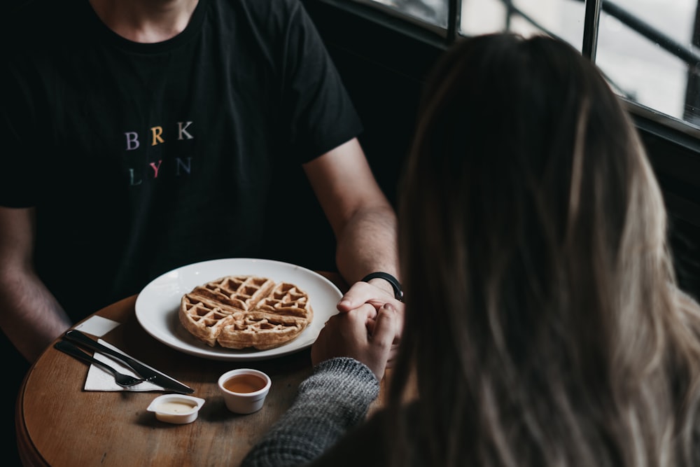 close-up photography of man and woman sits beside table