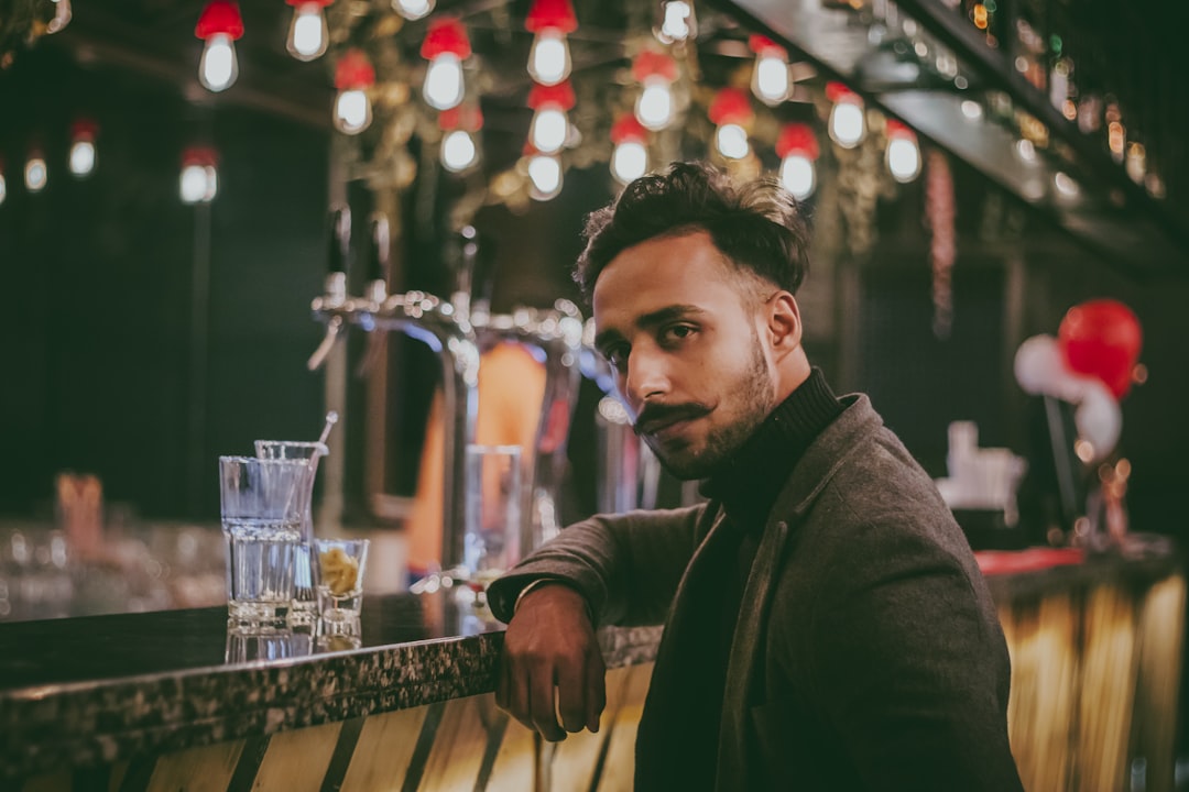 man sitting in front of bar