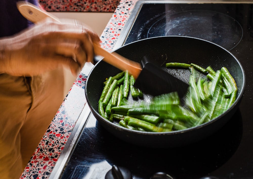 person cooking vegetables