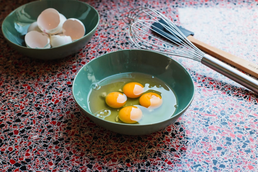 shallow focus photo of eggs in teal ceramic bowl