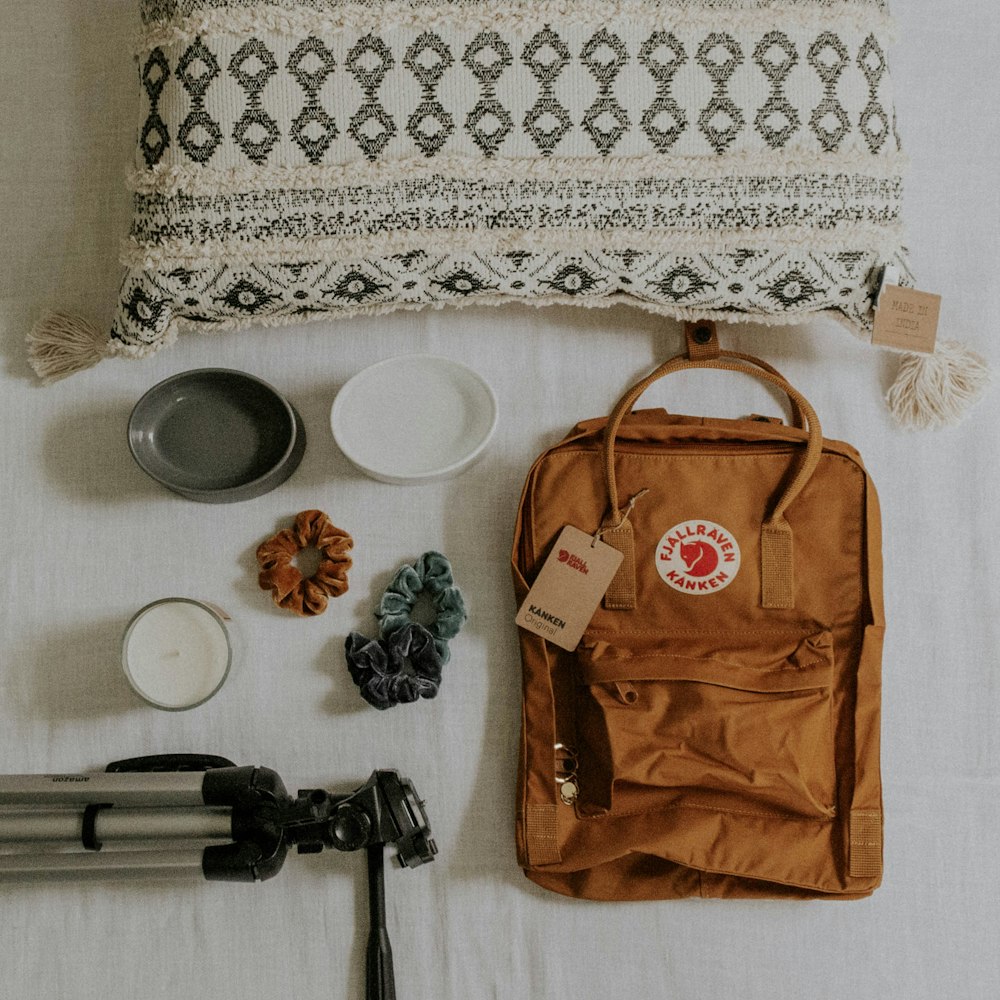 brown bag, camera tripod, ceramic bowls. and pillow