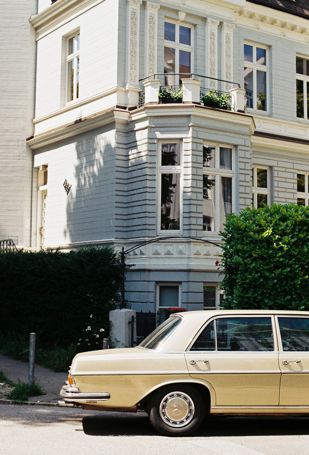 parked beige sedan beside house