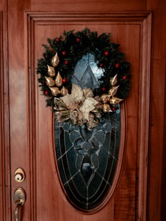 Close-up of a handcrafted door wreath decorated with baby-themed ornaments and delicate flowers.