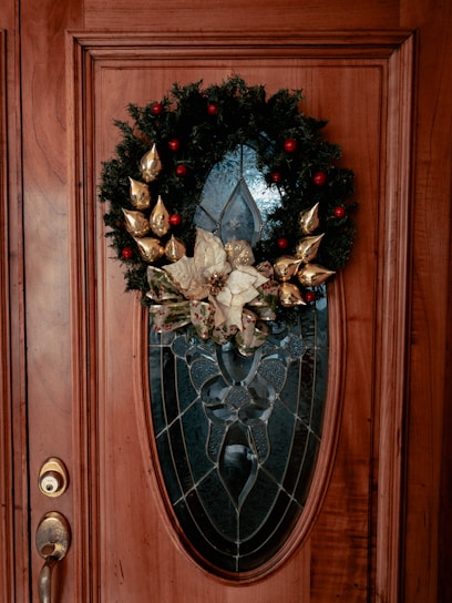 Close-up of a handcrafted door wreath decorated with baby-themed ornaments and delicate flowers.