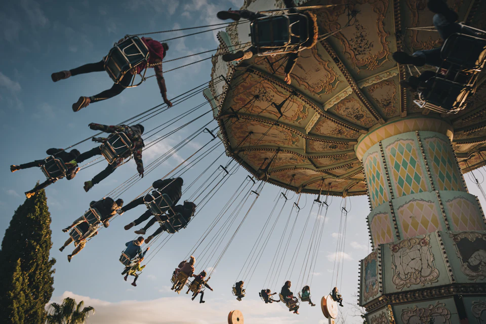 Lively scene at amusement park featuring colorful swing ride with people in motion