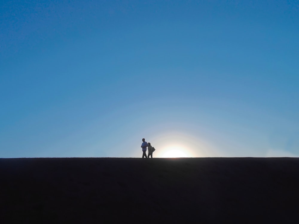 two people standing under blue sky