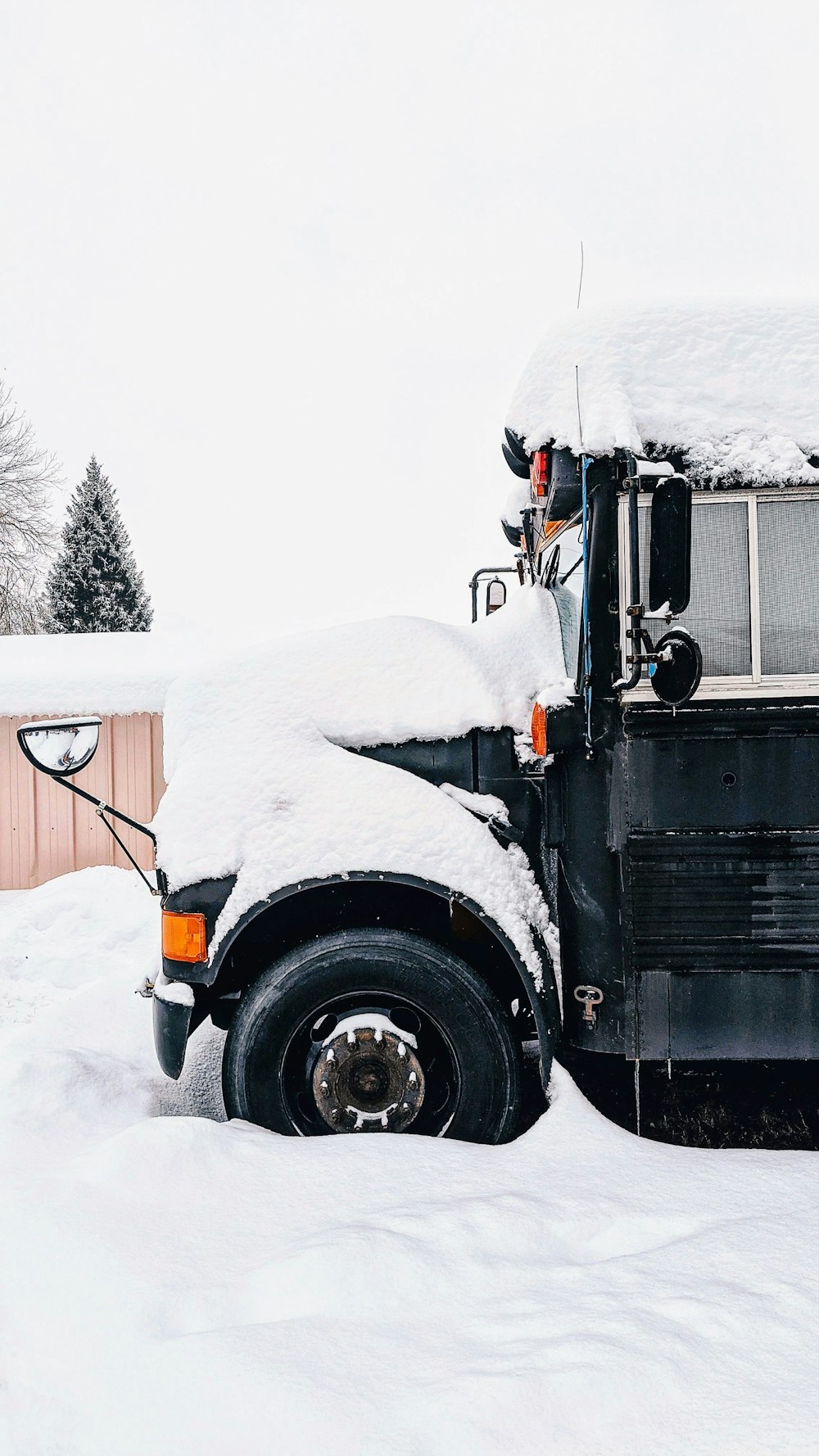 snow covered parked vehicle near fence